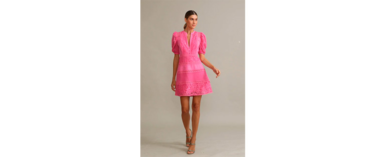 Modelo caucasiana com cabelos presos veste vestido rosa curto com detalhes em renda renascença na cor pink 